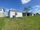 Back exterior view of a home with a well-maintained lawn and a screened-in porch at 4910 Lyric Dr, Mascotte, FL 34753