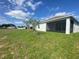 Back exterior view of a home with a well-maintained lawn and a screened-in porch at 4910 Lyric Dr, Mascotte, FL 34753