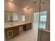 Bathroom boasts double vanity with cabinets and views to other rooms at 4910 Lyric Dr, Mascotte, FL 34753