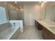 Bright bathroom with a soaking tub, a glass enclosed shower, and a double vanity at 4910 Lyric Dr, Mascotte, FL 34753