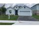 Charming single-Gathering home boasts a manicured lawn, paved driveway, and attached two-car garage at 4910 Lyric Dr, Mascotte, FL 34753