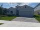 Charming single-story home featuring a gray exterior, well-maintained lawn, and a two-car garage at 4910 Lyric Dr, Mascotte, FL 34753