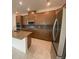 Spacious kitchen with stainless steel appliances, granite countertops, and wooden cabinetry at 4910 Lyric Dr, Mascotte, FL 34753