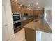 Modern kitchen featuring stainless steel appliances, granite countertops, and wooden cabinetry at 4910 Lyric Dr, Mascotte, FL 34753