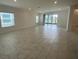 Bright living room featuring large windows and sliding glass doors leading to an outdoor space at 4910 Lyric Dr, Mascotte, FL 34753