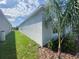 Exterior side view of home, showing well maintained grass and landscape, and blue sky at 4910 Lyric Dr, Mascotte, FL 34753