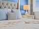 Bedroom close up featuring a tufted headboard bed with blue throw pillows and a nightstand with lamp at 9001 Flamingo Key Way, Kissimmee, FL 34747