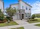 Charming two-story home features a stone facade, manicured lawn, paver driveway, and attached garage at 9001 Flamingo Key Way, Kissimmee, FL 34747