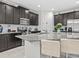 Modern kitchen featuring stainless steel appliances, dark wood cabinets, and a spacious granite island with bar seating at 9001 Flamingo Key Way, Kissimmee, FL 34747
