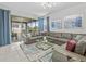Spacious living room with a large sectional sofa, glass coffee tables, neutral colors, and sliding glass doors at 9001 Flamingo Key Way, Kissimmee, FL 34747