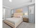 The bright primary bedroom features a tray ceiling, large windows, carpet, and an upholstered headboard at 9001 Flamingo Key Way, Kissimmee, FL 34747
