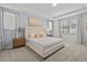 The bright primary bedroom features a tray ceiling, large windows, carpet, and an upholstered headboard at 9001 Flamingo Key Way, Kissimmee, FL 34747
