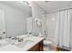 Clean bathroom with shower/tub combo, white tile, and a dark wood vanity at 2710 Manesty Ln, Kissimmee, FL 34747