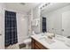 Bathroom with white subway tile surround, blue shower curtain, and wood vanity at 2710 Manesty Ln, Kissimmee, FL 34747
