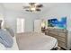Bedroom has a dresser with a large screen TV, ceiling fan and doorways to bathroom and closet at 2710 Manesty Ln, Kissimmee, FL 34747