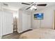 Cozy bedroom with a ceiling fan, a wall-mounted TV, and gray wood-look floors at 2710 Manesty Ln, Kissimmee, FL 34747
