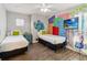 A whimsical Monsters, Inc. themed bedroom features twin beds and creative wall decor at 2710 Manesty Ln, Kissimmee, FL 34747