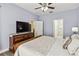 Bedroom with large screen TV, dresser, ceiling fan and doorways to bathroom and closet at 2710 Manesty Ln, Kissimmee, FL 34747