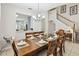 Dining room with long wooden table, 10 chairs, view into kitchen and stairs to second floor at 2710 Manesty Ln, Kissimmee, FL 34747