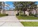 Two-story home with a two-car garage, lush landscaping, and a long driveway leading to the property at 2710 Manesty Ln, Kissimmee, FL 34747