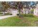 Two-story home with a two-car garage, mature trees, and lush landscaping creating a welcoming curb appeal at 2710 Manesty Ln, Kissimmee, FL 34747