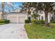 Charming two-story home with a two-car garage, mature trees, and lush landscaping in a well-kept yard at 2710 Manesty Ln, Kissimmee, FL 34747