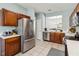 Kitchen view with wood cabinets, stainless steel refrigerator, and tile floors at 2710 Manesty Ln, Kissimmee, FL 34747
