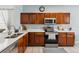Kitchen featuring wood cabinets, white countertops, stainless steel appliances, and tile flooring at 2710 Manesty Ln, Kissimmee, FL 34747