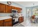Kitchen with stainless steel appliances, wooden cabinetry, tile floors, and eat in dining area at 2710 Manesty Ln, Kissimmee, FL 34747