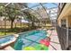 Screened-in pool area featuring a built-in hot tub and lush landscaping at 2710 Manesty Ln, Kissimmee, FL 34747