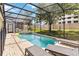 Screened-in pool area with a built-in hot tub, lounge chairs, and well-maintained landscaping at 2710 Manesty Ln, Kissimmee, FL 34747