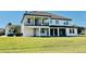 Rear view of a two-story residence featuring a grassy yard, rear covered patio, and second story balcony at 7443 Lake Albert Dr, Windermere, FL 34786