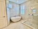 Bright bathroom showcasing a soaking tub, walk-in shower with glass enclosure, and stylish tile accents at 7443 Lake Albert Dr, Windermere, FL 34786