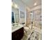 Cozy bathroom with a walk in shower, marble backsplash, dark wood vanity, and neutral colored walls at 7443 Lake Albert Dr, Windermere, FL 34786