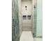 Modern shower featuring unique tile work and glass doors, plus convenient built-in shelves at 7443 Lake Albert Dr, Windermere, FL 34786