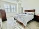 Bright bedroom with a queen bed, white walls, wood style flooring, and window with wooden shutters at 7443 Lake Albert Dr, Windermere, FL 34786