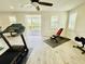 Large exercise room with treadmill, weight bench, hardwood floors, with access to a outdoor balcony at 7443 Lake Albert Dr, Windermere, FL 34786