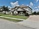 Side view of two-story residence shows stone and stucco elements, well manicured shrubs and brick driveway at 7443 Lake Albert Dr, Windermere, FL 34786