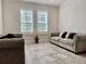 Bright sitting room boasts wood tile flooring, light-colored walls and comfortable sofas at 7443 Lake Albert Dr, Windermere, FL 34786