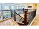 Open upper landing featuring dark wood railings and a view of the living area below at 7443 Lake Albert Dr, Windermere, FL 34786