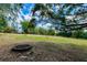 Large, open backyard area with a charming fire pit, perfect for outdoor gatherings and relaxation at 17358 Hwy 27, Clermont, FL 34715