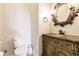 A well appointed powder room featuring a decorative vanity, mirror and a new toilet at 17358 Hwy 27, Clermont, FL 34715
