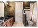Elegant bathroom boasts a stylish vanity with black granite, ornate mirror, and decorative dark wallpaper at 17358 Hwy 27, Clermont, FL 34715