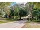 Long driveway leading to a beautiful home surrounded by lush landscaping and mature trees at 17358 Hwy 27, Clermont, FL 34715
