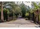 Private gated entrance leads to a long driveway surrounded by mature trees and lush greenery at 17358 Hwy 27, Clermont, FL 34715