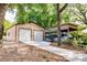 A metal outbuilding features two garage doors, complemented by an RV shelter, all set in a wooded area at 17358 Hwy 27, Clermont, FL 34715