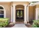 Elegant front entrance with decorative glass doors framed by white columns and manicured greenery at 17358 Hwy 27, Clermont, FL 34715