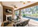 Inviting screened lanai with a pool, outdoor seating, a fireplace, and views of the surrounding greenery at 17358 Hwy 27, Clermont, FL 34715
