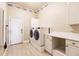 Well-equipped laundry room with washer, dryer, cabinets, and counter space for folding at 17358 Hwy 27, Clermont, FL 34715