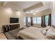 Beautiful main bedroom featuring a tray ceiling, comfortable furniture, a decorative rug, and access to the outside at 17358 Hwy 27, Clermont, FL 34715